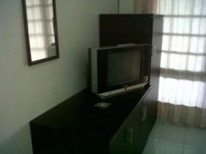 茂物格利亚帕拉尤宾馆的客房内的梳妆台上配有平面电视