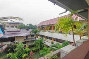 美娜多RedDoorz at Jalan Babepalar Rike Manado的从棕榈树建筑的阳台上可欣赏到风景