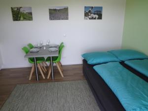 韦因地区拉奇Weinstraßenapartment Fam. Dietrich的一间卧室配有一张床和一张带绿椅的桌子