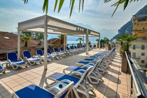 加尔达湖滨欧罗巴酒店 - 天空游泳池及全景的庭院里摆放着一排躺椅