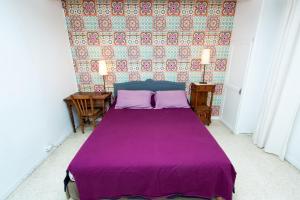 蒙彼利埃Montpellier Boutonnet avec jardin的一间卧室配有一张带两个枕头的紫色床