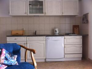 亚布拉纳茨Apartment Stinica 31b的厨房配有白色橱柜和白色洗碗机。