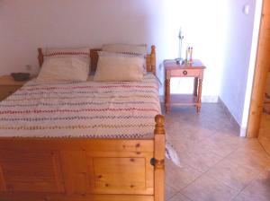 亚布拉纳茨Apartment Stinica 31b的一间卧室配有一张木床和床头柜