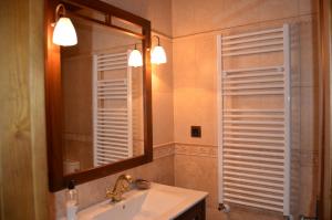Muñogalindocasa rural La Gabina的一间带水槽和镜子的浴室以及窗户。