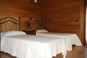 Muñogalindocasa rural La Gabina的木墙客房的两张床
