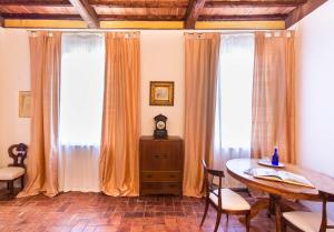蒙特罗尼德阿尔比亚圣·法比亚诺城堡乡村民宿的一间带桌子和2个窗户的用餐室