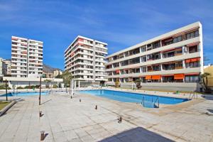 多列毛利诺斯La Nogalera Deluxe Apartment Torremolinos的两个高楼前的游泳池