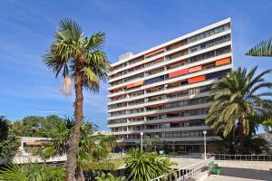 多列毛利诺斯La Nogalera Deluxe Apartment Torremolinos的一座高大的建筑,前面有棕榈树