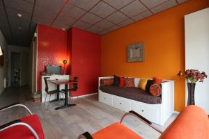 费尔普特雷萘维住宿加早餐旅馆的一间卧室设有橙色的墙壁、一张床和一张书桌
