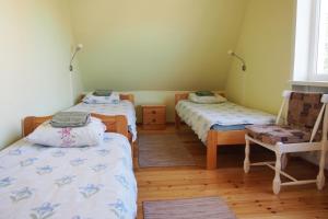哈普萨卢曼尼旅馆的客房设有两张单人床和一把椅子。