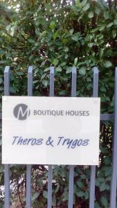 阿特米达Theros & Trygos Boutique Houses - ATH Airport的灌木丛前的标志