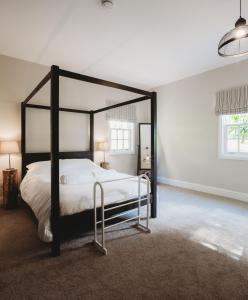 圣安德鲁斯Orchard Cottage的卧室配有黑白天蓬床