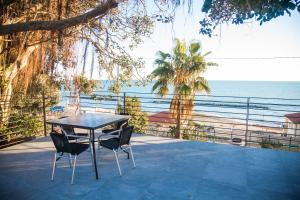 圣托·斯特凡诺·阿尔马尔Terramata Resort Case Vacanza的俯瞰大海的庭院内的桌椅