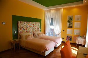 索伦托秘密花园住宿加早餐旅馆的卧室设有两张黄色墙壁的床