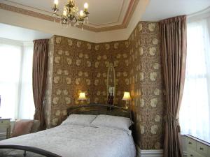 兰迪德诺克里斯特雷敦别墅酒店的一间卧室配有一张床和一个吊灯