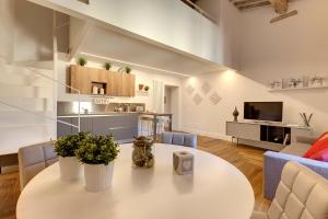 佛罗伦萨Mamo Florence - Mattonaia Apartment的一间带白色桌子的客厅和一间厨房