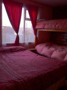 纳塔列斯港梅林达旅馆的一间卧室设有两张双层床和一扇窗户。