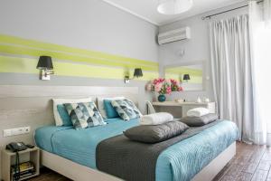马蒂米尔托酒店的一间卧室配有一张带蓝色床单和枕头的床。