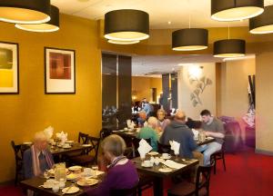 绍斯波特Royal Clifton Hotel的一群坐在餐厅桌子上的人