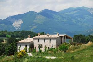 卡利Agriturismo Molleone的山丘上以山为背景的房子
