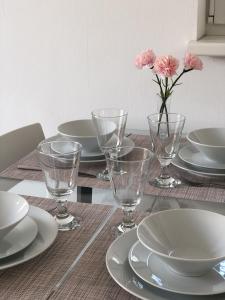 格拉茨High 5的一张桌子,上面有盘子和玻璃杯,花瓶上有粉红色的花