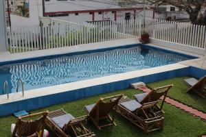 查察拉卡斯Hotel Villas del Rey的一个带三把椅子的游泳池
