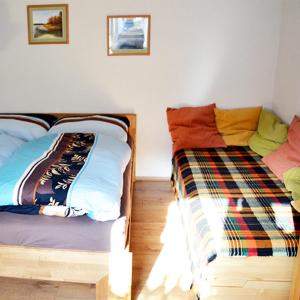 格明德Ferienwohnung Blockheide的一间卧室配有两张带彩色毯子的床