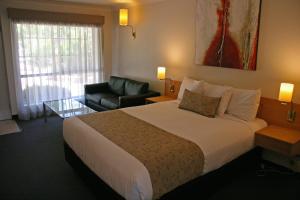 旺加拉塔赫尔米塔什汽车旅馆的酒店客房带一张大床和一把椅子