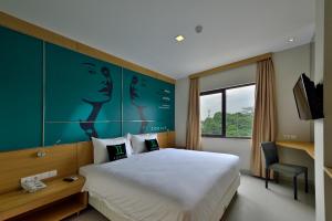 雅加达Zodiak MT Haryono by KAGUM Hotels的一间设有大床和窗户的酒店客房