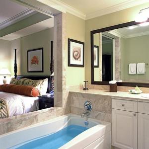 哈勃岛情人节滨海度假酒店的带浴缸、床和镜子的浴室
