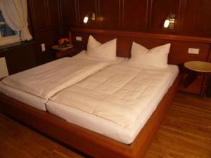 费尔贝特Elektro-Hotel Rosenhaus GmbH的一张配有白色床单和枕头的大床