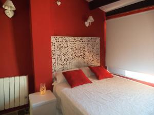 塞戈尔韦Casa Rural Media Luna的一间卧室设有红色的墙壁和一张带红色枕头的床