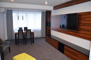 贝乌哈图夫斯波特酒店的客房设有带椅子的餐桌和平面电视。