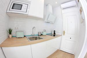 多列毛利诺斯New Central Studio Torremolinos的白色的厨房配有水槽和微波炉