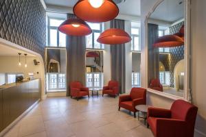 维尔纽斯Hotel Vilnia的一间设有红色椅子和镜子的等候室
