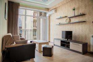 第比利斯TB Apart-Hotel in Tbilisi 1的客厅配有电视、沙发和椅子
