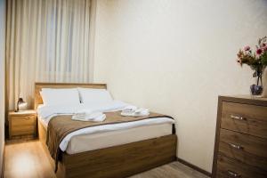 第比利斯TB Apart-Hotel in Tbilisi 1的一间卧室配有一张床,上面有两条毛巾