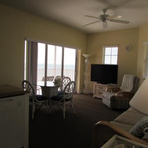 迈尔斯堡海滩爱迪生海滨别墅 的客厅配有电视和桌椅