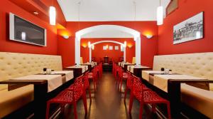布拉格精品酒店的餐厅拥有红色的墙壁和桌子以及红色的椅子