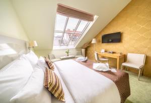 布拉格Grandium Hotel Prague的卧室配有一张白色大床和一张书桌