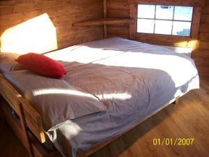 威廉堡The Hobbit House的一间卧室配有一张红色枕头的床