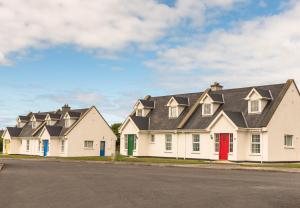 巴利巴宁Ballybunion Cottages No 22的一排带红色门的白色房屋