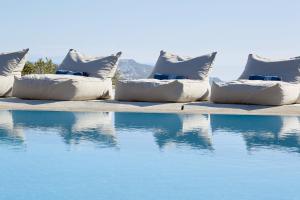 图罗斯Amare Mykonos的游泳池旁的枕头排