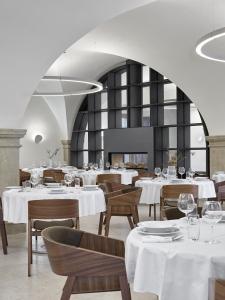 大帕夫洛维采Lotrinský hotel的餐厅设有白色的桌椅和白色的天花板
