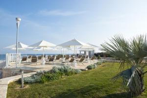滨海波利尼亚诺Vilu Suite Mare的海滩上一排椅子和遮阳伞