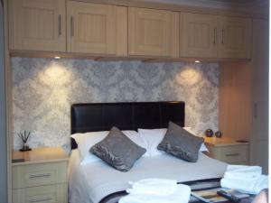 贝图瑟科伊德Glenwood Guesthouse Betws-y-coed的一间卧室配有一张带白色床单和木制橱柜的床。