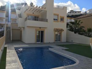 罗哈莱斯Quesada Luxury Villa的一座房子前面设有游泳池