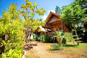高兰Baan O K Chawkoh的花园中树木繁茂的房屋