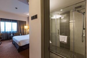 北赖佩奈阳威酒店的酒店客房带一张床和一个玻璃淋浴间