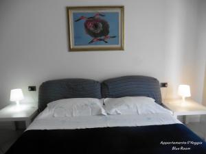 波焦阿卡伊阿诺Appartamento il Veggio的一间卧室配有一张带两盏灯的床,墙上挂着一张照片